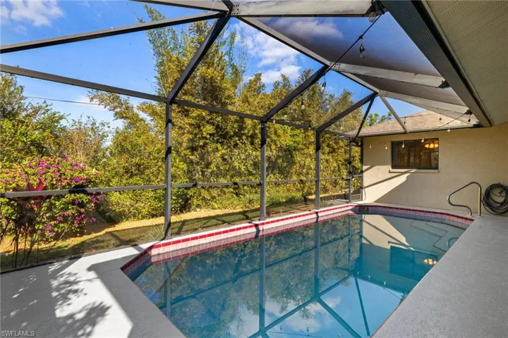 View of swimming pool featuring a lanai