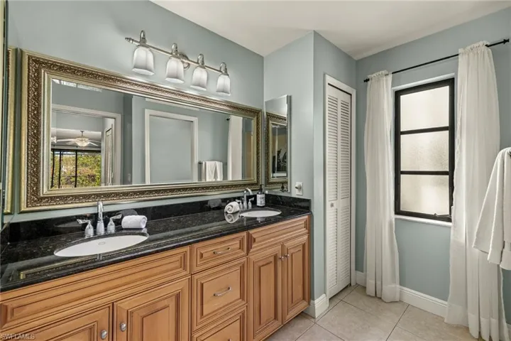 Bathroom with tile patterned flooring, vanity, and ceiling fan