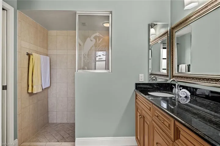 Bathroom featuring vanity and tiled shower