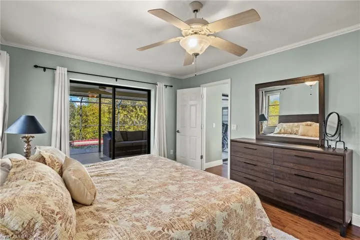 Bedroom featuring access to exterior, hardwood / wood-style floors, ceiling fan, and crown molding