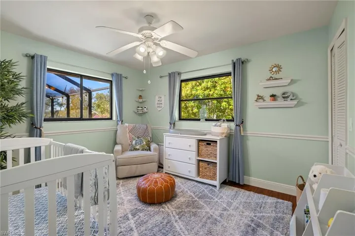 Bedroom with ceiling fan, a closet, multiple windows, and a nursery area