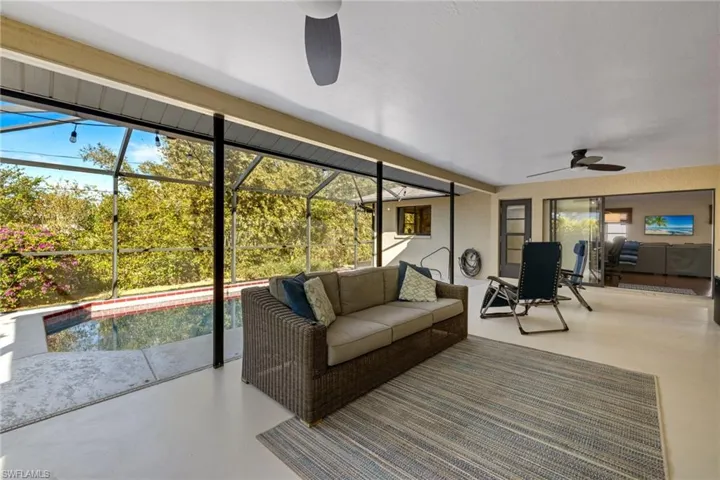 Sunroom with plenty of natural light, ceiling fan, and a swimming pool