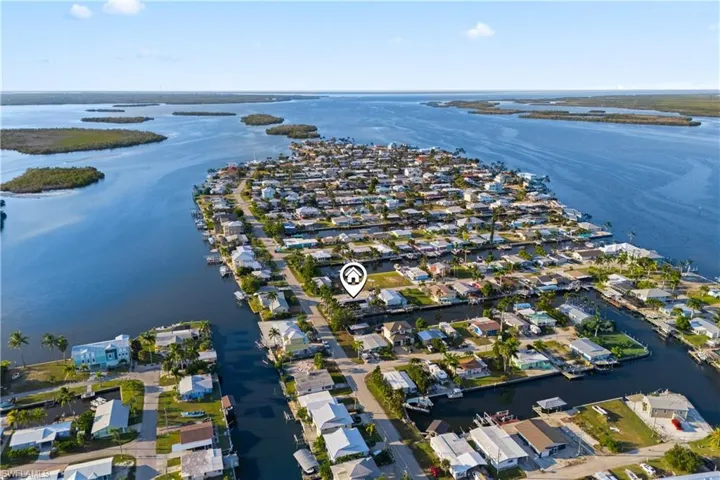 Elevated view showing serene waterfront setting, private dock, and the vibrant island community.