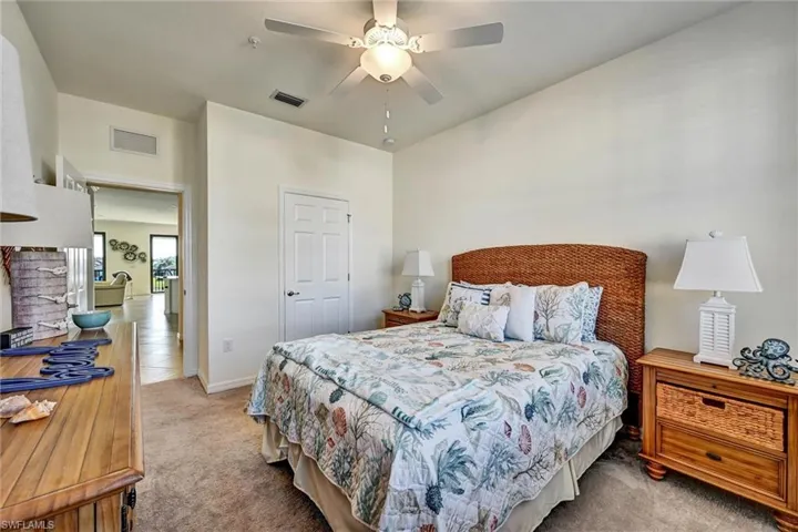 Carpeted bedroom with a ceiling fan and baseboards