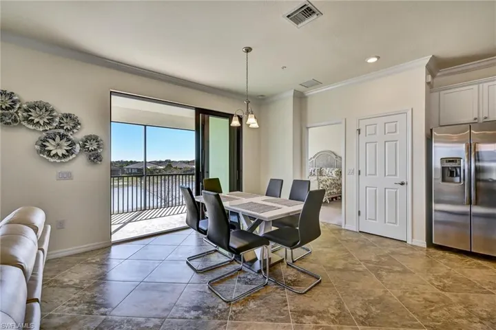 Dining area with crown molding, a water view, and hanging lights