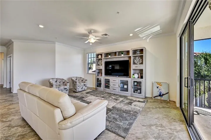 Living room featuring a ceiling fan, recessed lighting, and ornamental molding