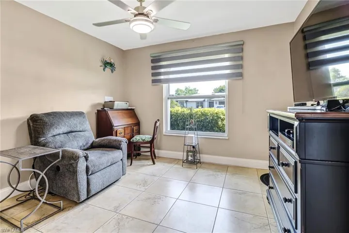 Living area featuring ceiling fan and light tile floors