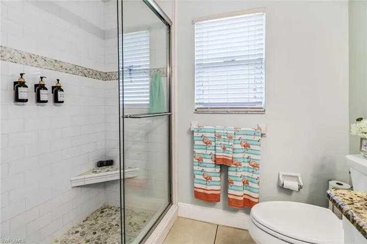 Bathroom with tile floors, plenty of natural light, toilet, and vanity