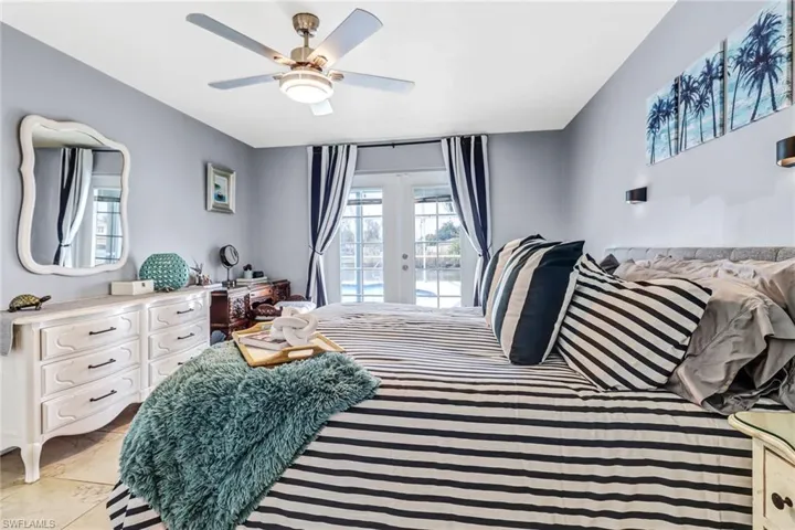 Bedroom with ceiling fan, access to exterior, and light tile floors