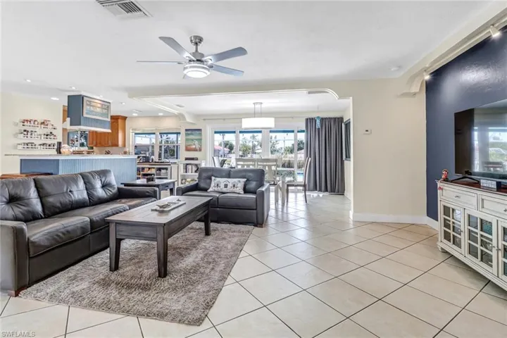 Living room with ceiling fan and light tile floors