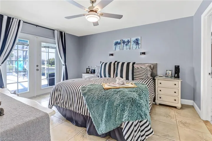 Tiled bedroom featuring access to outside, french doors, and ceiling fan