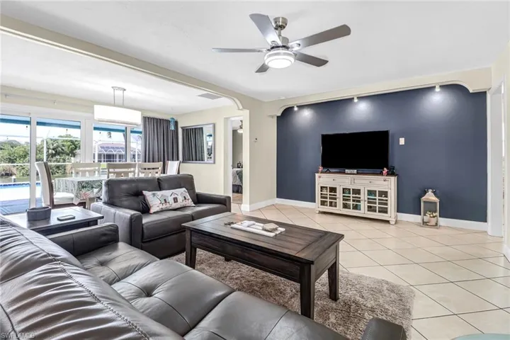 Living room featuring ceiling fan and light tile flooring