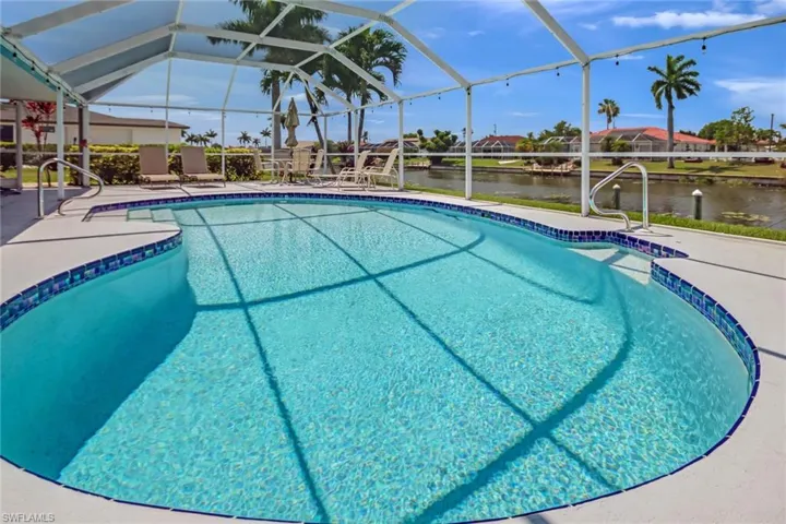 View of swimming pool featuring glass enclosure