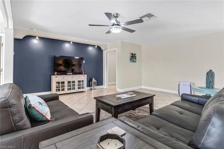Living room featuring ceiling fan and light tile flooring