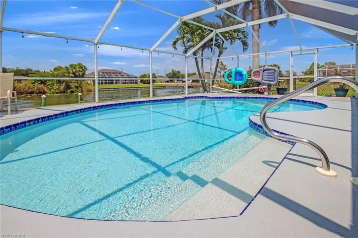 View of pool featuring glass enclosure and a patio