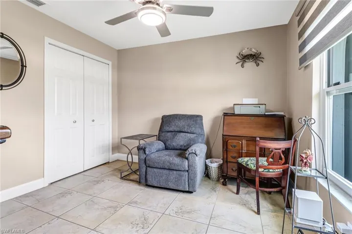 Living area featuring a healthy amount of sunlight, tile flooring, and ceiling fan