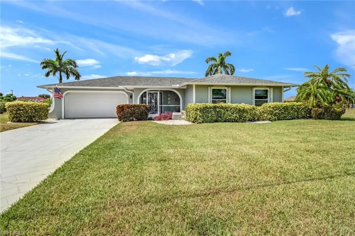 Single story home featuring a garage and a front yard