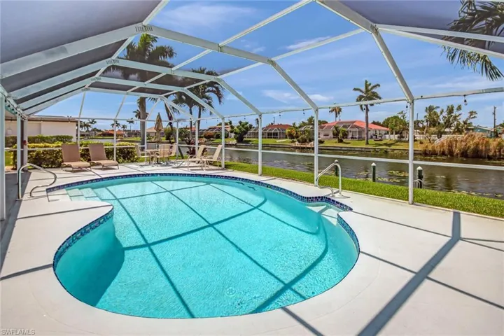 View of pool featuring a patio, a lanai, and a water view