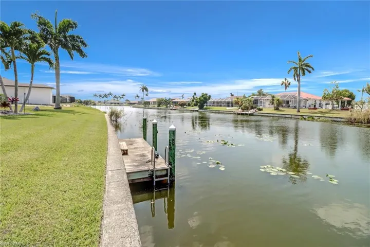 View of dock featuring a yard and a water view