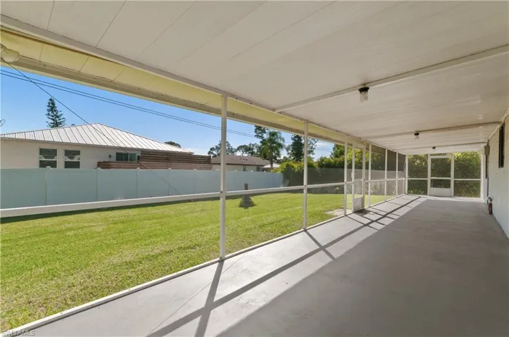 Screened lanai featuring a concrete floor, solid overhead roof, integrated light fixtures, and a fenced backyard