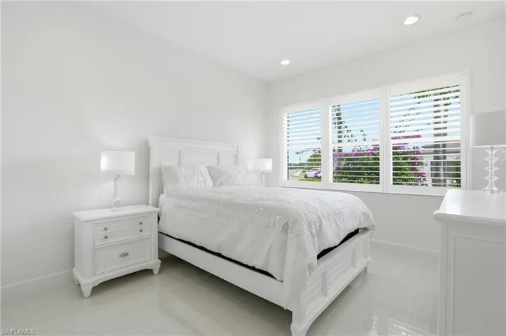 Interior space featuring polished tile flooring, recessed ceiling lighting, and multi-panel plantation shutters