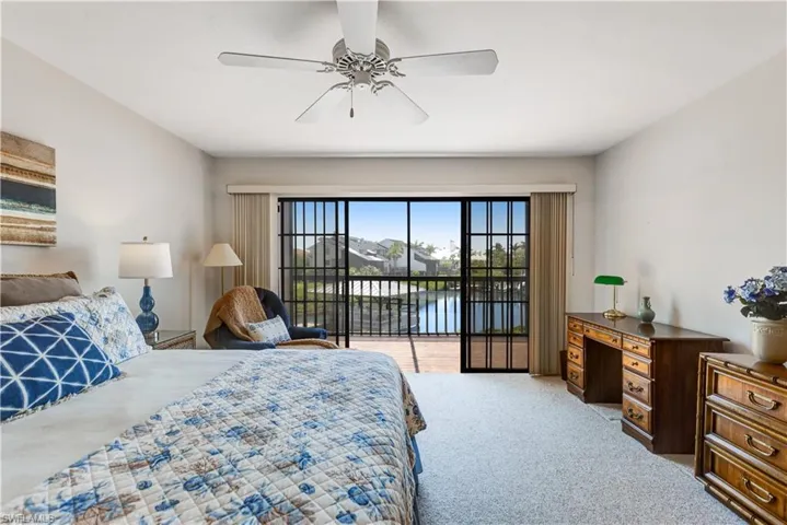 Spacious primary bedroom with balcony access and water views.