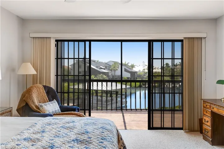 Spacious primary bedroom with balcony access and water views.