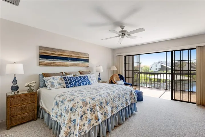 Spacious primary bedroom with balcony access and water views.