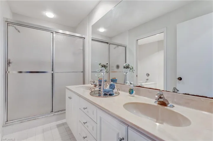 primary bathroom with double sinks and a walk-in shower