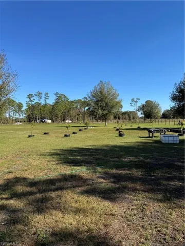 View of home's community with a rural view and a yard