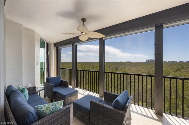 Sunroom with a ceiling fan, outdoor seating, and a balcony