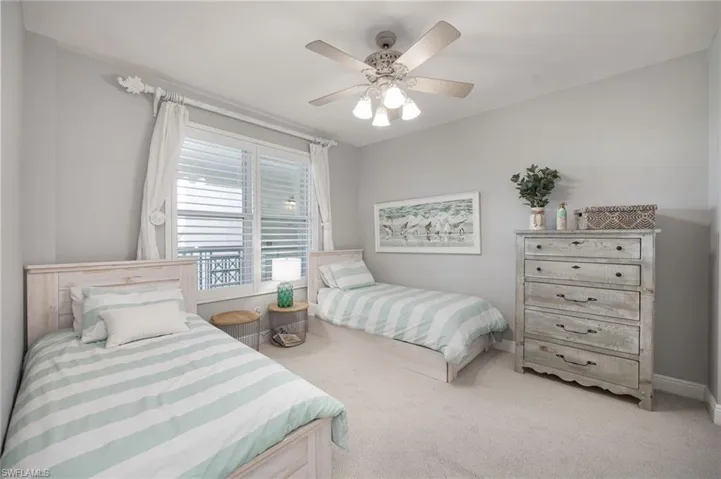 Bedroom with light colored carpet and a ceiling fan