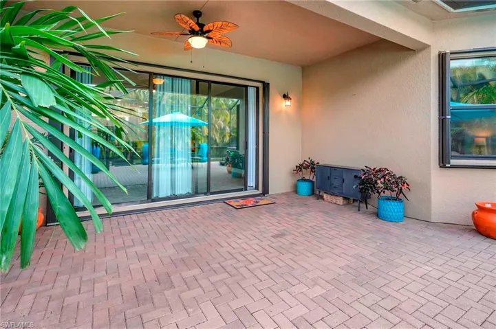 Doorway to property with ceiling fan and a patio area