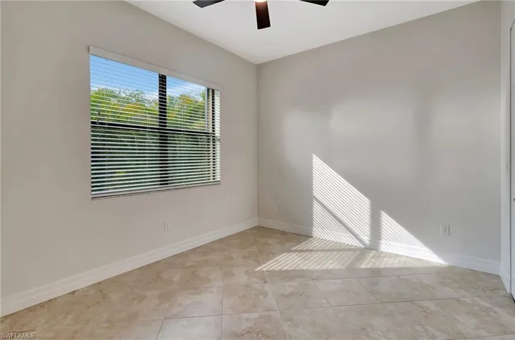 Tiled empty room featuring ceiling fan