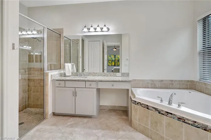 Bathroom featuring vanity, independent shower and bath, and tile patterned flooring