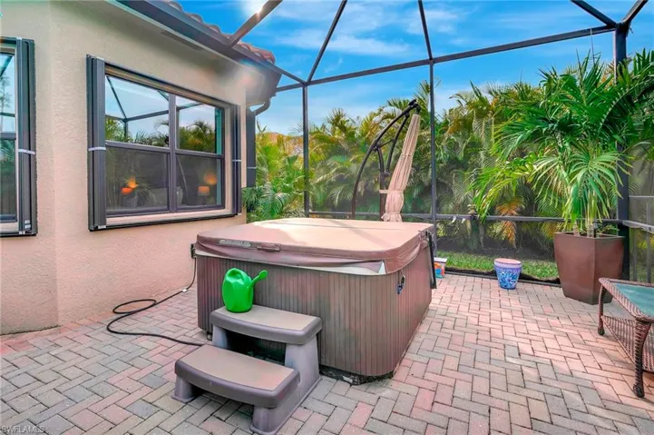 View of patio featuring a lanai and a hot tub