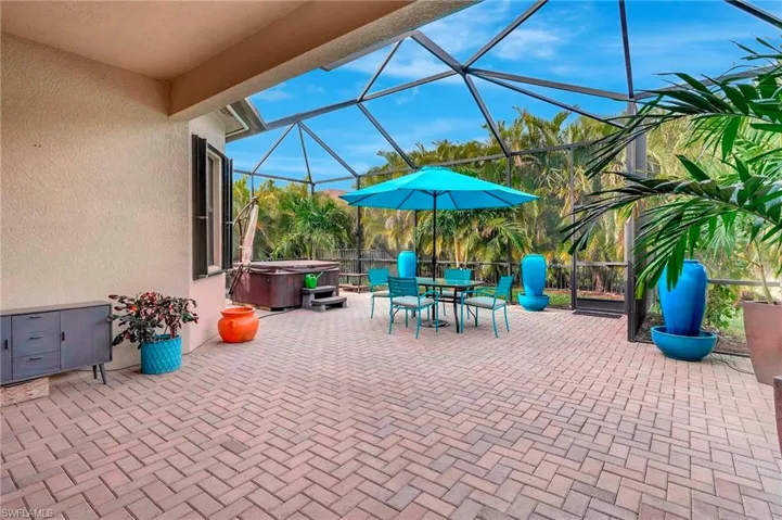 View of patio / terrace with a lanai and a hot tub