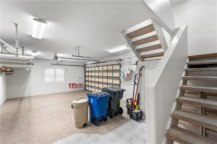 View of the oversized garage. Epoxy finished floor and it is air conditioned.Stairs lead to the bonus room with a 1/2 bath on the second level.