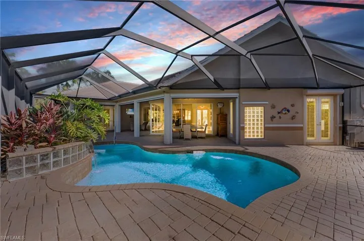 Custom designed pool with waterfall, pavered pool deck enhances the under truss outdoor living area!