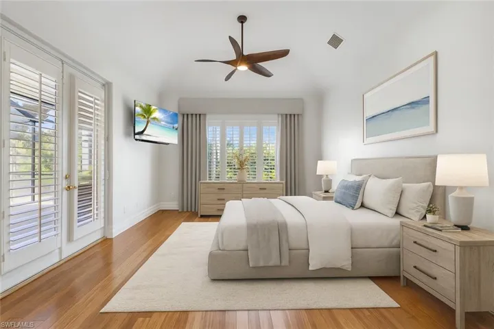 Virtually staged primary bedroom. Beautiful wood flooring. Plantation shutters and lots of natural light spills into this space! You have access to your lanai.