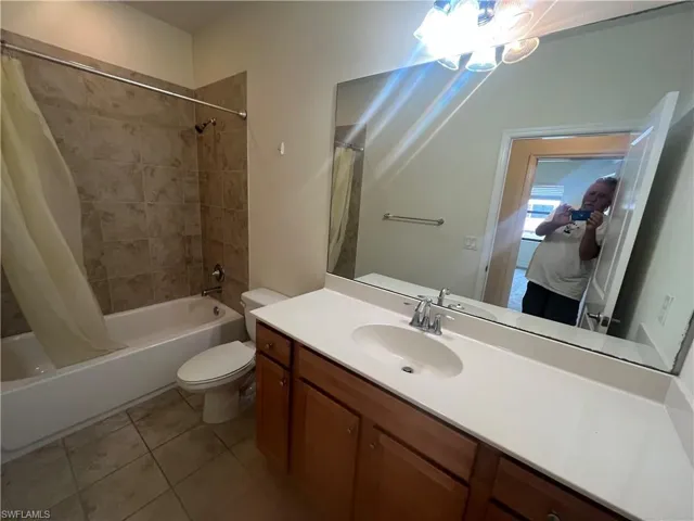 Full bathroom featuring shower / tub combo, vanity, tile patterned flooring, and ensuite bathroom