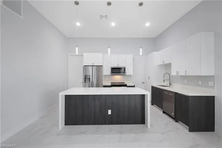 Kitchen with quartz countertops and under island shiplap decor in finished home
