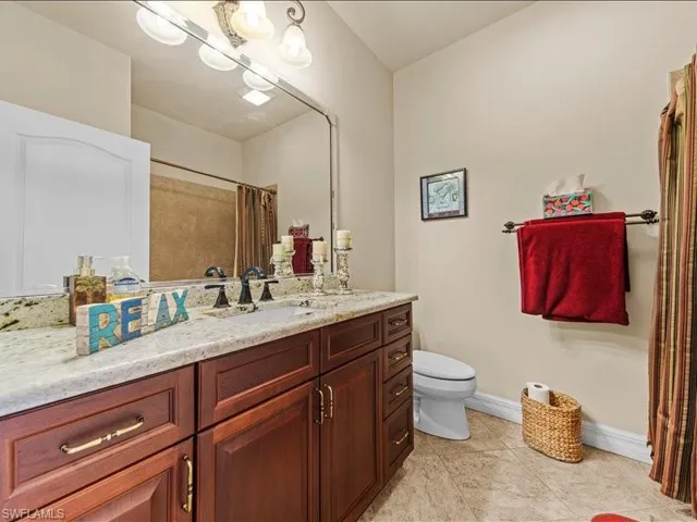Full bath with vanity, light tile patterned flooring, and a shower with shower curtain