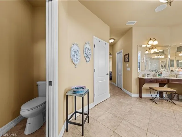 Full bath with vanity, light tile patterned flooring, and backsplash