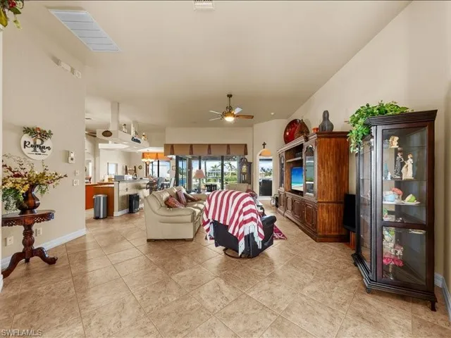 Living room with a ceiling fan and light tile patterned floors