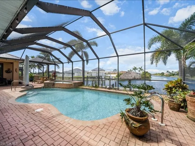 View of pool featuring a sunroom, glass enclosure, and a water view