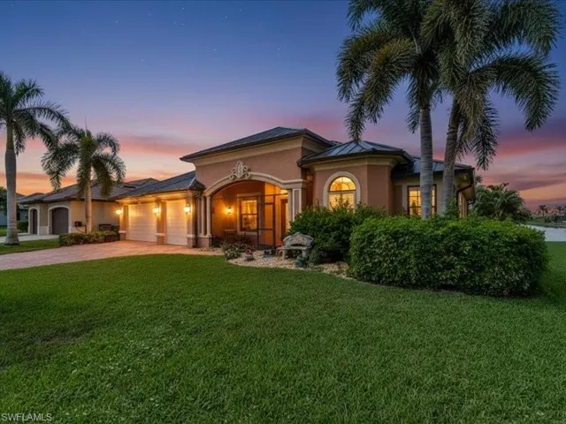 Mediterranean / spanish-style home with a yard, driveway, stucco siding, and a garage