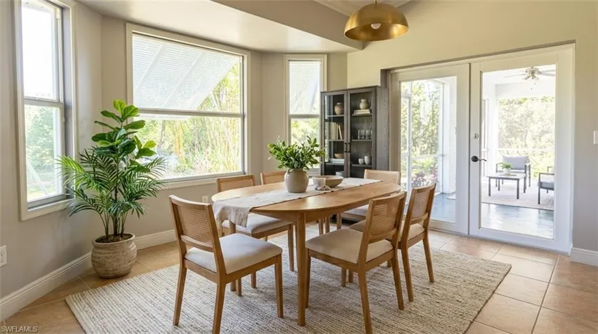 Bay window, neutral tile flooring, brass-finish pendant lighting, and full-glass panel doors opening to a screened porch