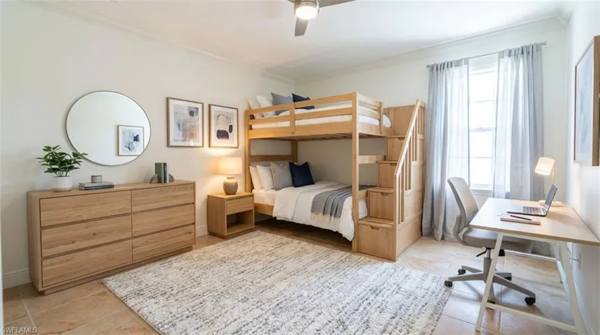 Neutral-toned room featuring tile flooring, crown molding, and a ceiling fan with integrated lighting