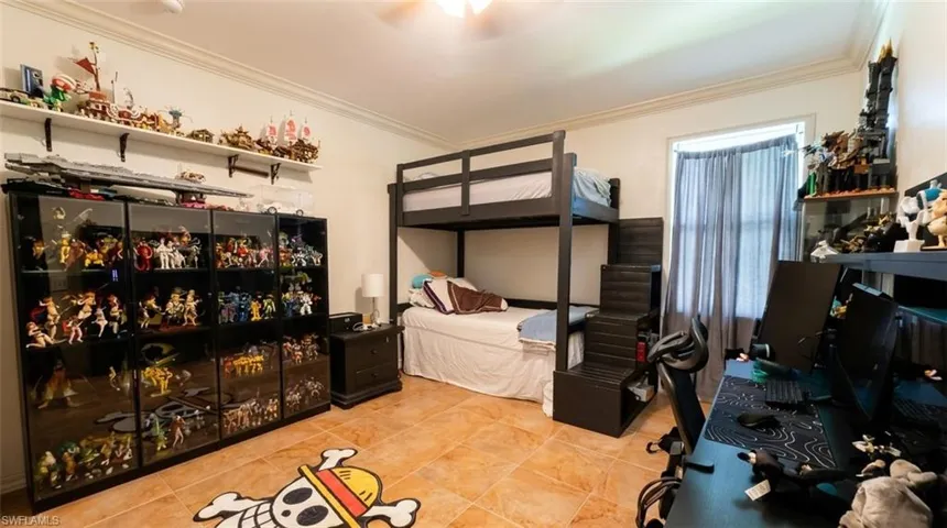 Room featuring tile flooring, crown molding, and a built-in wall shelf
